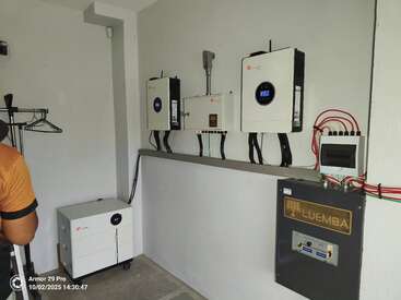 La imagen muestra un cuarto de servicio limpio y organizado, con inversores solares, baterías, paneles de control eléctrico, cables etiquetados y un sistema Luemba instalado en la pared.