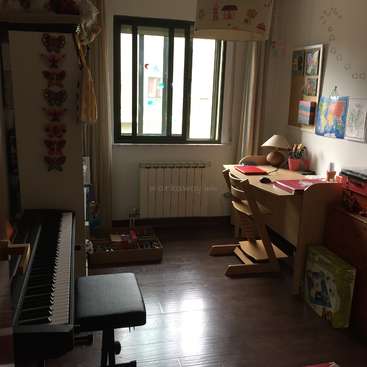 L'image représente une pièce confortable avec un piano, un bureau et une chaise, avec une fenêtre, une lampe et des œuvres d'art sur les murs, avec un sol en bois et un mur blanc.