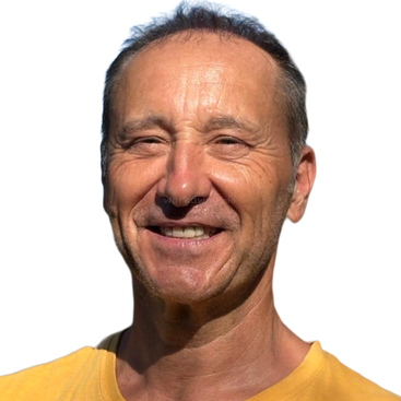 Un hombre de mediana edad con el pelo corto sonríe ampliamente. Lleva una camisa amarilla. El fondo es blanco liso, lo que resalta su expresión alegre.
