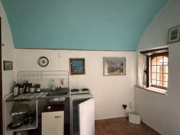 Cette photo montre une petite cuisine rustique dotée d'un plafond voûté bleu, d'un coin cuisine simple, d'un mini-réfrigérateur ouvert, de décorations murales et d'une fenêtre laissant entrer la lumière naturelle.