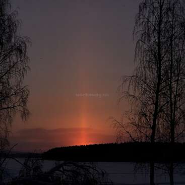 The image depicts a serene sunset over a body of water, with trees silhouetted against the vibrant orange sky and a subtle watermark reading \"workaway.info\".