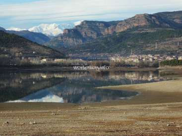 The image depicts a serene landscape featuring a lake, mountains, and a town in the background, with a watermark reading "workawayinfo" in the center.