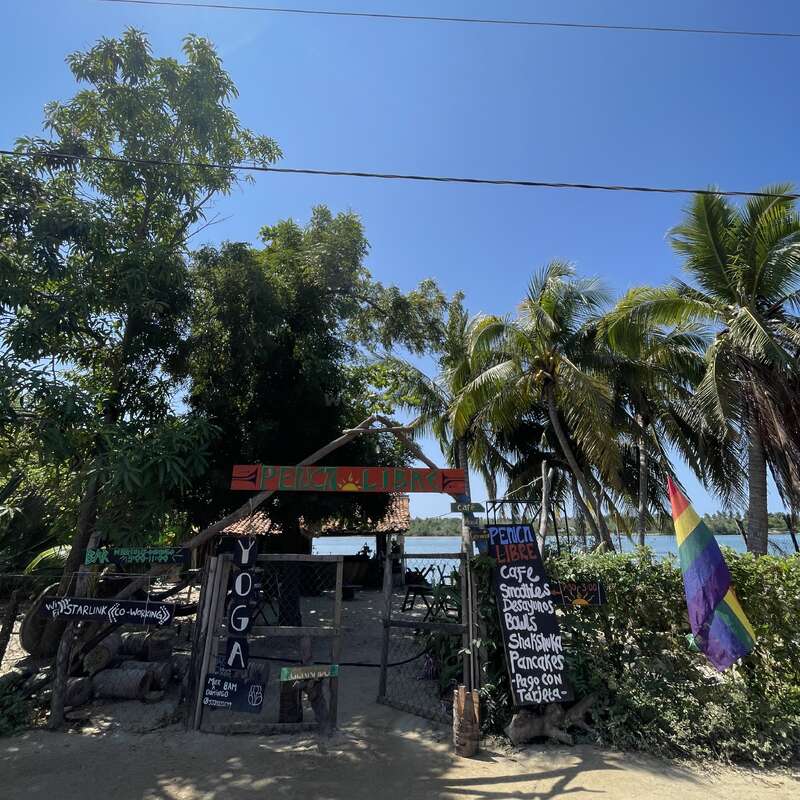 Um café rústico chamado “Penca Libre” fica debaixo de palmeiras à beira-mar, oferecendo ioga, Wi-Fi, smoothies, panquecas e um ambiente tropical acolhedor e descontraído.