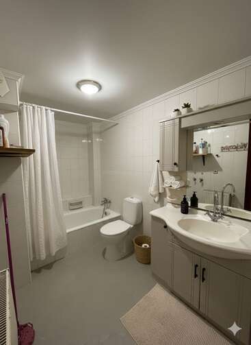 This image shows a clean, modern bathroom with white tiles, a bathtub with a shower curtain, toilet, vanity with mirror, storage shelves, and decorative plants.