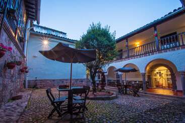 The image depicts a serene outdoor setting, featuring a large tree and a body of water, with a grassy area in the foreground and a wooden fence in the background. The scene exudes tranquility and natural beauty.