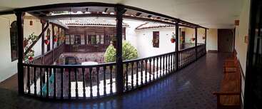 The image depicts a spacious room with a high ceiling, featuring a large window and a doorway, likely a living room or office space, with a neutral color scheme and minimalist decor.