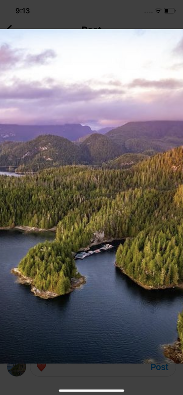 Un paysage serein avec des îles boisées verdoyantes entourées d'une eau d'un bleu profond, de collines ondulantes et d'un magnifique ciel peint de nuages roses et violets.
