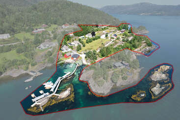 Esta foto aérea mostra uma ilha particular cênica contornada em vermelho, com casas, docas, barcos, vegetação exuberante, margens rochosas e cercada por água azul clara.