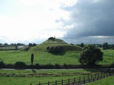 The image depicts a serene landscape featuring a grassy hill, a fence, and a cloudy sky, with a subtle watermark in the center.