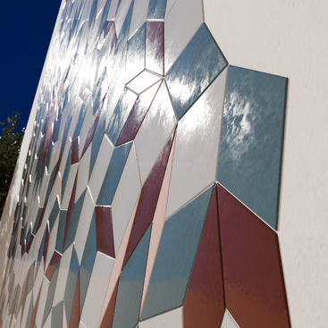 This image shows a wall covered with geometric, reflective tiles in shades of blue, white, and red, creating a mesmerizing, mosaic pattern under sunlight.