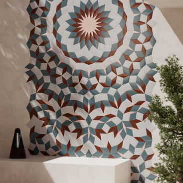 This image shows a wall with a colorful geometric mosaic pattern in blue, white, pink, and brown. A metronome and green plant are present.