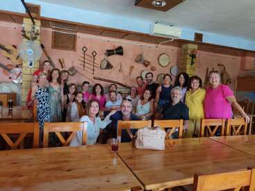 Un groupe de personnes pose ensemble à l'intérieur d'un restaurant décoré d'instruments de musique sur le mur. Elles sourient, apprécient la compagnie des autres et ont l'air heureuses.