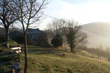 Das Bild zeigt eine ruhige Landschaft mit einem Haus, Bäumen und einem Gewässer, die ein Gefühl von Ruhe und natürlicher Schönheit hervorruft. Die Szene zeichnet sich durch ihre friedliche Atmosphäre aus.