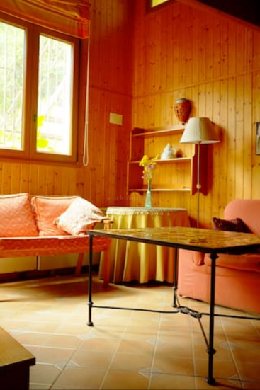 The image depicts a cozy living room with wood paneling, a couch, coffee table, and a window, exuding a warm and inviting atmosphere.
