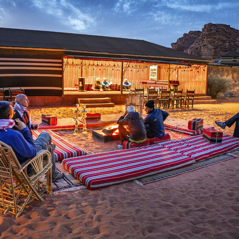La imagen muestra a un grupo de personas sentadas en torno a una mesa, enzarzadas en una discusión, con algunos gestos y otros escuchando atentamente, lo que transmite una sensación de colaboración y entendimiento mutuo.