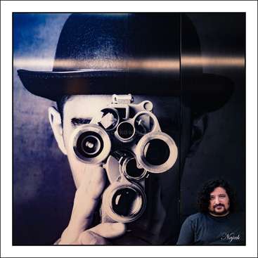 Das Bild zeigt einen Mann, der eine alte Kamera mit vier Objektiven in der Hand hält und eine Melone trägt, daneben ein kleineres Foto eines anderen Mannes mit dunklen Haaren und einem Bart.