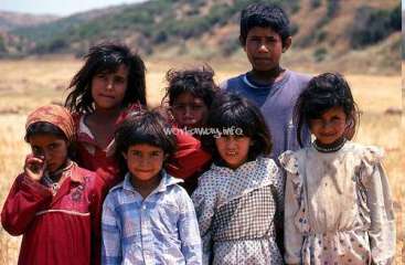 Das Bild zeigt eine Gruppe von sieben Kindern, die auf einem Feld stehen. In der Mitte des Bildes ist ein Wasserzeichen mit der Aufschrift "World-Map.info" eingeblendet.