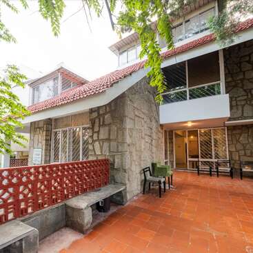 A imagem retrata um ambiente externo sereno, com uma grande árvore e um corpo d'água, com uma área gramada ao fundo, evocando uma sensação de tranquilidade e beleza natural.