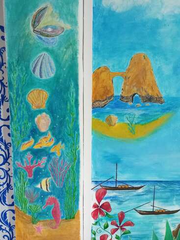 La imagen muestra dos cuadros llenos de color: uno representa una escena submarina con conchas, peces y un caballito de mar; el otro, acantilados, barcos, flores y el mar.