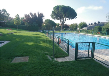 Das Bild zeigt einen ruhigen Außenbereich mit einem Pool und einer grünen Umgebung, mit einem Zaun im Hintergrund, der ein Gefühl von Entspannung und Ruhe hervorruft. Wahrscheinlich handelt es sich bei der Szene um ein Wohngebiet.