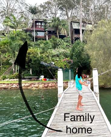 A child stands barefoot on a wooden dock fishing, with "Family home" text and an arrow pointing up the hill to a house surrounded by lush greenery.