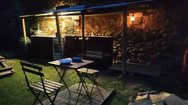 The image shows a cozy outdoor space with a table and chairs, surrounded by a fence, featuring a small garden and a wooden fence, evoking a sense of warmth and relaxation.