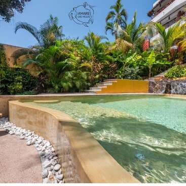 Une piscine tropicale paisible, entourée d'une végétation luxuriante, rehaussée de touches de pierre et de murs d'un jaune éclatant, avec une eau d'un bleu cristallin et une atmosphère sereine et accueillante.