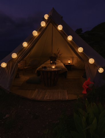 Ein gemütliches, warm beleuchtetes Zelt ist mit Lichterketten geschmückt. Drinnen gibt es Stühle, einen Tisch, ein Bett und leuchtende Lampen; draußen wachsen Blumen.