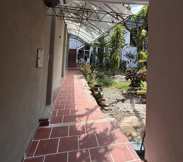 This collage showcases a modern house exterior, tiled hallway with garden, two bedrooms with wooden ceilings, ample closets, bunk bed, and simple colorful bedding.
