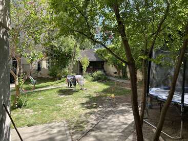 The image depicts a serene backyard scene with a trampoline, trees, and a house in the background, evoking a sense of tranquility and relaxation.