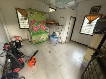 Esse quarto tem piso de azulejo branco, colchão floral verde, material de limpeza, cortinas laranja, caixas de armazenamento, prateleiras de metal e parece meio bagunçado e utilitário.