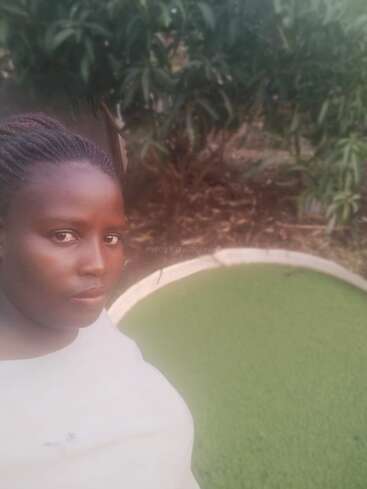 The image depicts a woman standing in front of a green lawn and a tree, with a subtle watermark reading "workaway.info" in the center.