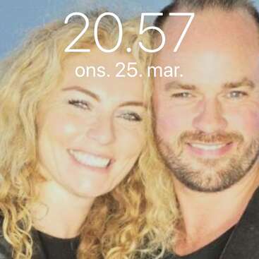 La imagen muestra un primer plano de un hombre y una mujer con el pelo rubio, sonriendo a la cámara, superpuesto a un texto en blanco que dice \"20.57 ons. 25. mar.\"