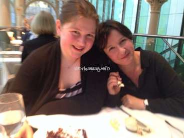 The image depicts two women sitting at a table, with a watermark reading "workaway.info" in the center. The women are dressed in dark attire.