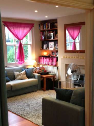 The image depicts a cozy living room with a fireplace, bookshelf, and comfortable seating, featuring a warm and inviting atmosphere.