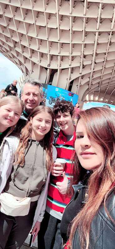 Das Bild zeigt eine Gruppe von Menschen, die zusammenstehen, eine Mischung aus Männern und Frauen, die alle in die gleiche Richtung schauen und für ein Foto posieren. Sie sind in Freizeitkleidung gekleidet.