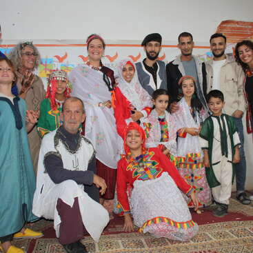 The image depicts a group of people from diverse backgrounds gathered together, showcasing unity and diversity, with a focus on community and social connections, highlighting the importance of inclusivity and cultural understanding.
