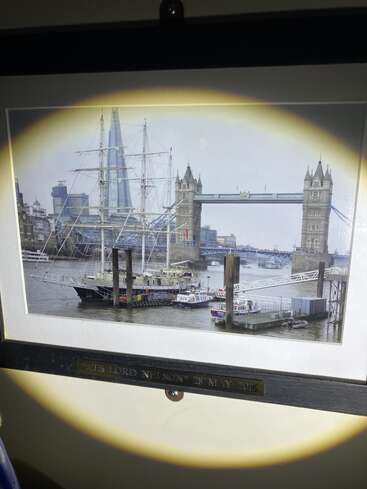 Dieses Bild zeigt ein gerahmtes Foto des Schiffs "STS Lord Nelson" in der Nähe der Tower Bridge in London, mit The Shard im Hintergrund, vom 28. Mai 2015.