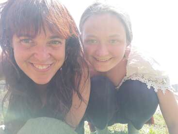 La imagen muestra a dos mujeres posando para un selfie, con la mujer de la izquierda de pelo castaño largo y la mujer de la derecha de pelo castaño corto.