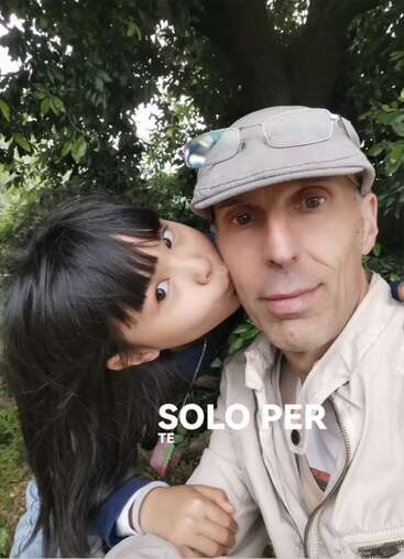 A young girl kisses a man on the cheek as they pose for a selfie outdoors. The text "SOLO PER TE" appears at the bottom.