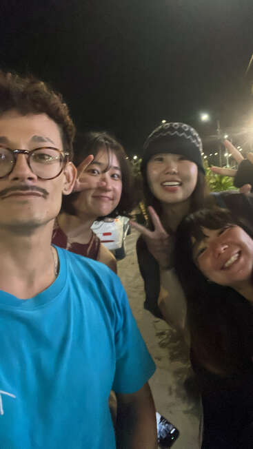 Cuatro amigos disfrutan de una divertida noche de fiesta. Sonríen, posan para una selfie, hacen el signo de la paz y posan al aire libre bajo las brillantes luces de la calle.