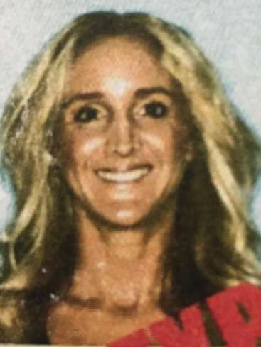 The image is a close-up of a woman\'s face with long blonde hair, wearing a red top, set against a light blue background.