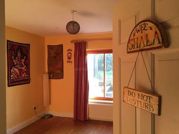 A imagem mostra uma sala serena com uma janela, com uma placa \"DO NOT DISTURB\", uma lâmpada e obras de arte nas paredes, exalando um ambiente tranquilo.