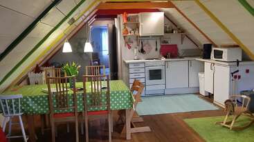L'image représente un espace de vie confortable avec une table et des chaises, dans une atmosphère chaleureuse et accueillante, probablement destiné à mettre en valeur la décoration intérieure et l'esthétique d'une maison.