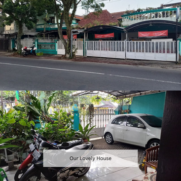 Esta imagen muestra una encantadora casa con una valla turquesa y exuberantes plantas. El camino de entrada alberga un coche blanco y una moto, destacando un hogar acogedor y acogedor.