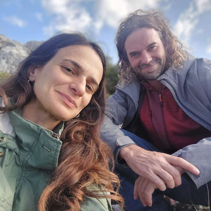 L'image montre un selfie d'un homme et d'une femme posant en plein air, la femme à gauche et l'homme à droite.