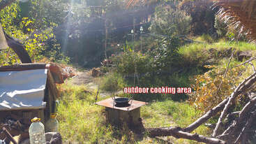 The image depicts a serene outdoor setting, featuring a fire pit surrounded by a wooden fence, with a table and chairs in the background, evoking a sense of tranquility and relaxation.