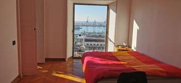 The image depicts a room with a large window, showcasing a cityscape outside. The room is furnished with a table and chairs, and features a decorative wall hanging. The overall atmosphere is one of elegance and sophistication.
