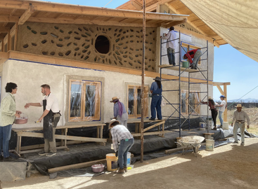 La imagen muestra a un grupo de personas construyendo una casa, algunas de pie sobre un andamio y otras trabajando en las paredes exteriores, todas con ropa informal y sombreros.