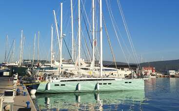 L'image montre un groupe de bateaux amarrés dans un port de plaisance, avec quelques bateaux flottant sur l'eau. Les bateaux sont tous de tailles et de formes différentes, et ils sont tous orientés dans des directions différentes.